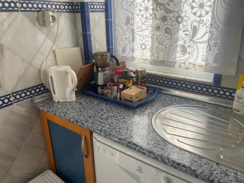 una cocina en miniatura con encimera y fregadero en Apartamentos Puerto Sherry, en El Puerto de Santa María