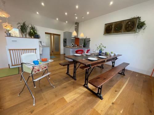 a dining room and kitchen with a wooden table and chairs at 1 Woodlands in Llandysul