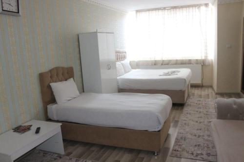 a hotel room with two beds and a window at okyanus apart laçin apart in Bostaniçi