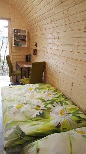 a bed with flowers on it in a room at Glamping Pod im Wald mit Einzelbetten in Nordholz