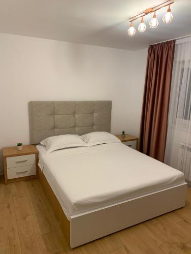 a bedroom with a large bed with white sheets at Sunny Apartment in Suceava in Suceava