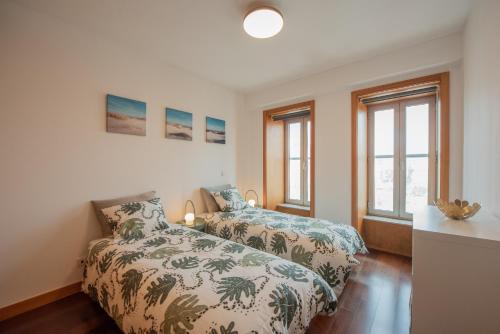 sypialnia z 2 łóżkami i 2 oknami w obiekcie Porto Metro-At-Home Apartment w mieście Matosinhos