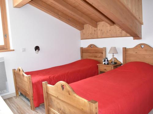 - 2 lits dans une chambre avec des draps rouges dans l'établissement Appartement 3 pièces au dernier étage, 2 balcons, proche téléphérique et espace aqualudique - FR-1-464-87, à Pralognan-la-Vanoise