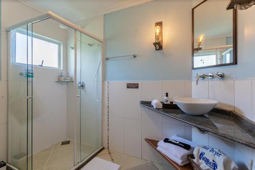 a bathroom with a glass shower and a sink at Penareia Floripa Beach Hotel in Florianópolis