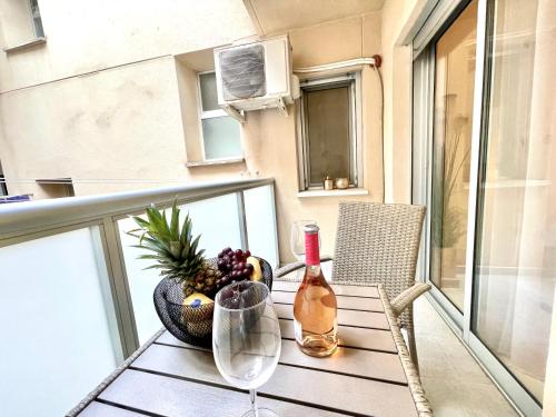 una mesa con una botella de vino y un bol de fruta en el balcón en Modern 2 Bedroom Apartment Fuengirola en Fuengirola
