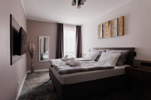 a bedroom with a large bed in a room at Villa Bauhaus Wellness Apartman in Siófok