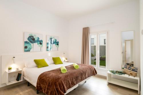 ein weißes Schlafzimmer mit einem großen Bett und grünen Kissen in der Unterkunft Villa Salvia by Villa Plus in Playa Blanca