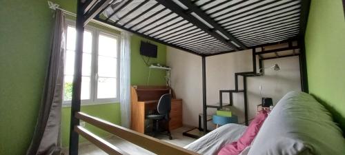 ein Schlafzimmer mit einem Bett und einem Schreibtisch in einem Zimmer in der Unterkunft chambre familiale dans maison au calme in Segonzac