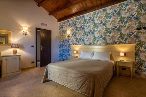 a bedroom with a large bed with a floral wallpaper at Duomo Apartments Cefalù in Cefalù