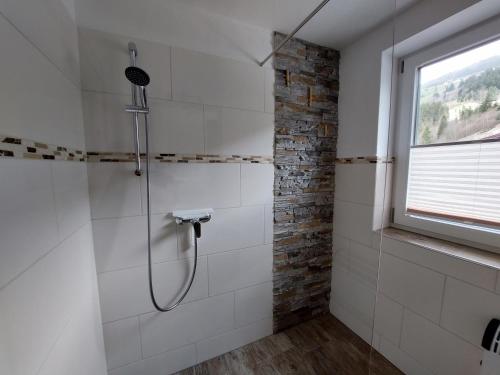 La salle de bains est pourvue d'une douche et d'une fenêtre. dans l'établissement Ferienwohnung Almsuite Fritz, à Wald im Pinzgau