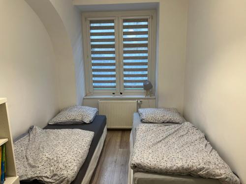 2 Betten in einem Zimmer mit Fenster in der Unterkunft Apartament 3 pokojowy z parkingiem in Ząbkowice Śląskie