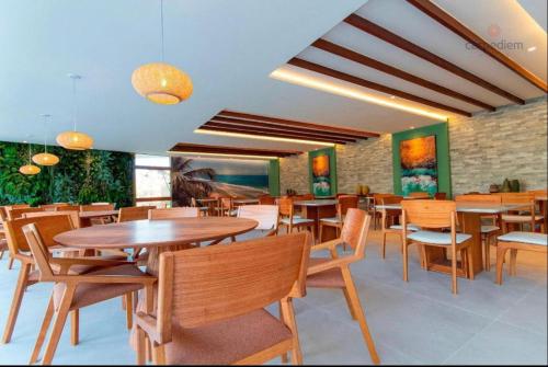 une salle à manger avec des tables et des chaises en bois dans l'établissement Mana Beach Flat Prime, à Ipojuca