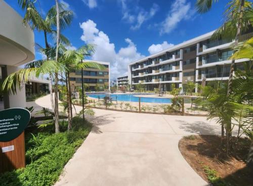 een resort met een zwembad en een gebouw bij Mana Beach Flat Prime in Ipojuca