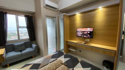 een woonkamer met een tv en een bank in een kamer bij Rifky Room Studio Transpark in Bulanbulan