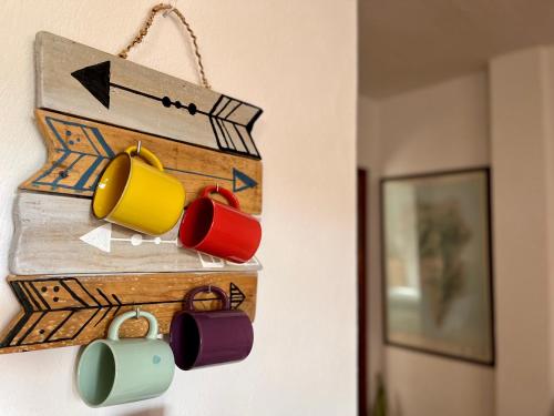 a group of coffee cups hanging on a wall at Casa Los Palitos in Monte de Breña