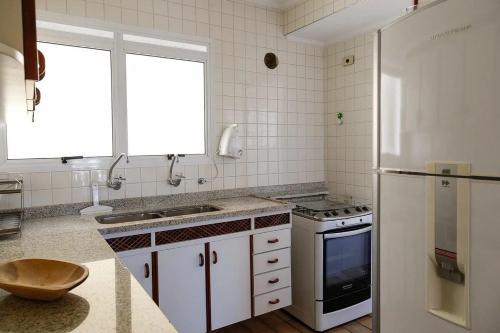 a kitchen with a sink and a refrigerator at Condomínio Acqua de Riviera - Módulo 3 in Riviera de São Lourenço