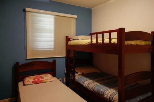 a bedroom with two bunk beds and a window at Condomínio Acqua de Riviera - Módulo 3 in Riviera de São Lourenço