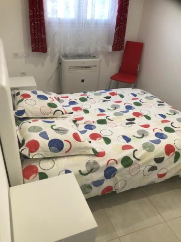 a small bedroom with a bed and a red chair at Appart 2 in Carla-Bayle