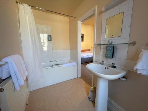 a bathroom with a sink and a bath tub at The Sandbanks in Barmouth