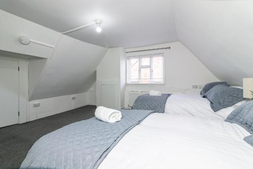 a bedroom with two beds and a window at The Oldtown Lodge in Stevenage