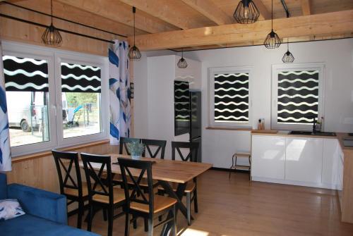 a dining room with a table and chairs and windows at Forest House Sasino in Sasino