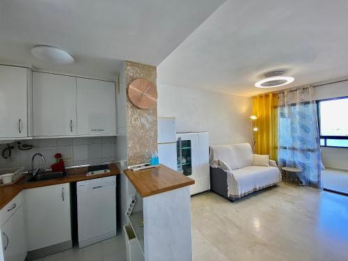 a kitchen and living room with a couch and a chair at LuxBenidorm in Benidorm