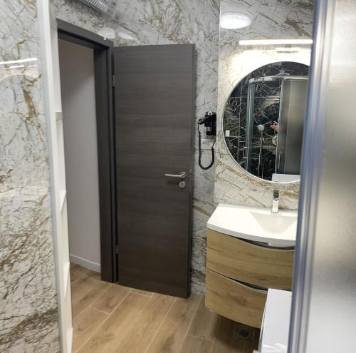 a bathroom with a sink and a door with a mirror at Town Center Apartments in Zadar
