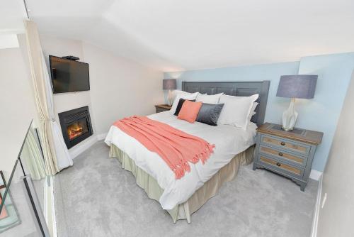 a bedroom with a large bed and a fireplace at Harbourfront Executive Stay in Victoria