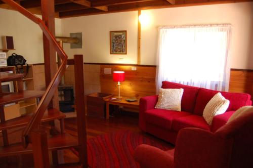 a living room with a red couch and a window at Beyonderup Falls Adult Retreat in Nannup