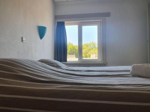 Ce lit se trouve dans un dortoir doté d'une fenêtre. dans l'établissement Hotel Restaurant Sence, à Burgh-Haamstede