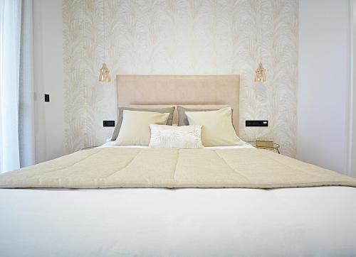 a bedroom with a large white bed with two pillows at Tu oasis con piscina en Portonovo Sanxenxo in Sanxenxo