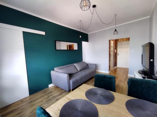 ein Wohnzimmer mit einem Sofa und einem Tisch in der Unterkunft Apartament przy Zamku Krzyżackim in Malbork