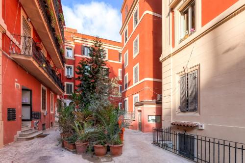 un callejón en una ciudad con edificios y macetas en Guest House VATICAN MUSEUMS PARVA DOMUS, en Roma