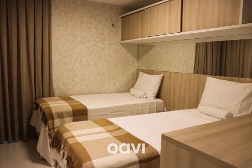 two beds in a small room withermottermottermott at Qavi - Apto em Resort Beira Mar Cotovelo #InMare43 in Parnamirim