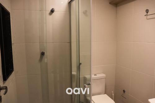 a bathroom with a toilet and a glass shower at Qavi - Apto em Resort Beira Mar Cotovelo #InMare43 in Parnamirim