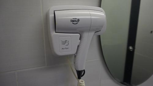 a hair dryer in a bathroom with a mirror at Smile Hotel Subang Airport in Shah Alam
