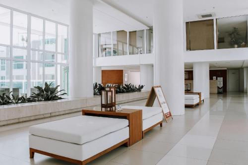 a hospital lobby with a couch and a chair at Qavi - Apto em Resort Beira Mar Cotovelo #InMare43 in Parnamirim