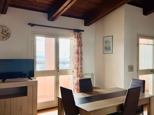 a dining room with a table and a large window at Approdo Apartments in Isola Rossa