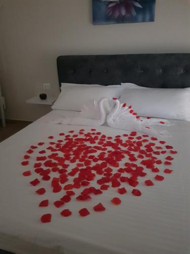 a bed with a bunch of red roses on it at Lotus Apartments in Vlorë