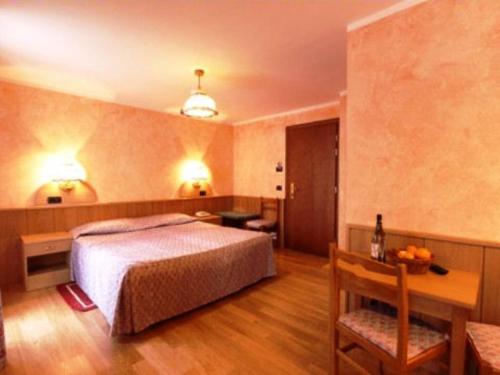 ein Hotelzimmer mit einem Bett und einem Tisch und einem Tisch sidx sidx in der Unterkunft Hotel Tersiva in Valtournenche