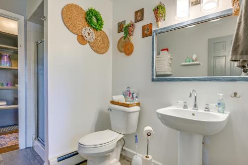 a bathroom with a toilet and a sink and a mirror at Central Michigan Vacation Rental Near Frankenmuth! in Birch Run