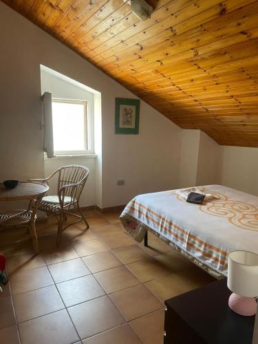 a bedroom with a bed and a table and a window at il casale di Bruno e Pina in Pantana