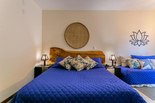 a bedroom with a blue bed and a mirror at Penareia Floripa Beach Hotel in Florianópolis