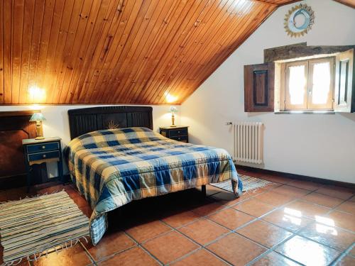 1 dormitorio con cama y techo de madera en Casa Cabreiros de Cima en Melgaço