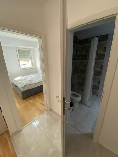 a bedroom with a bed and a door leading to a bathroom at srle home in Skopje