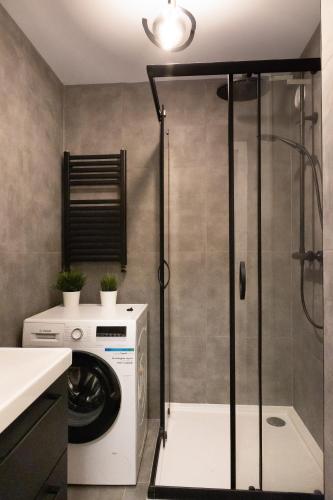 a bathroom with a washing machine and a shower at ClickTheFlat Conrada Apart Rooms in Warsaw