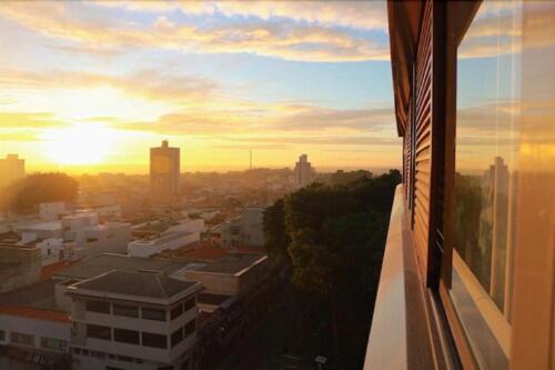 a view of a city with the sunset from a building at Hotel Del Fiol in Tatuí