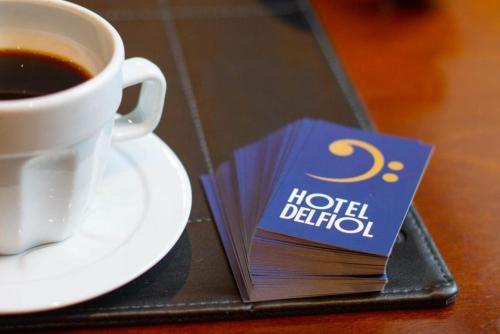 a book next to a cup of coffee on a table at Hotel Del Fiol in Tatuí