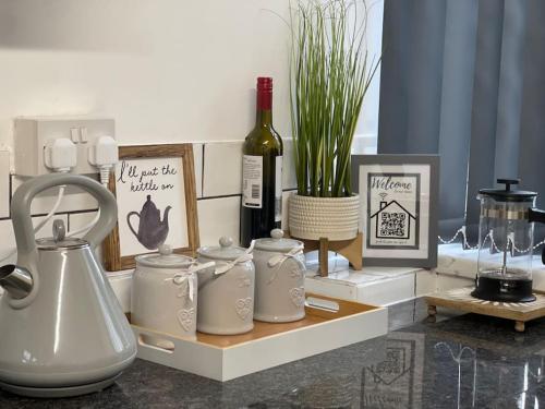 a counter with a table with a bottle of wine and jars at Casa Lobo's Beautiful Suites Apartment 1 free offroad parking in Fallings Park