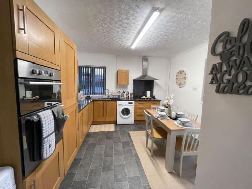 a large kitchen with a table and a stove at Casa Lobo's Beautiful Suites Apartment 1 free offroad parking in Fallings Park